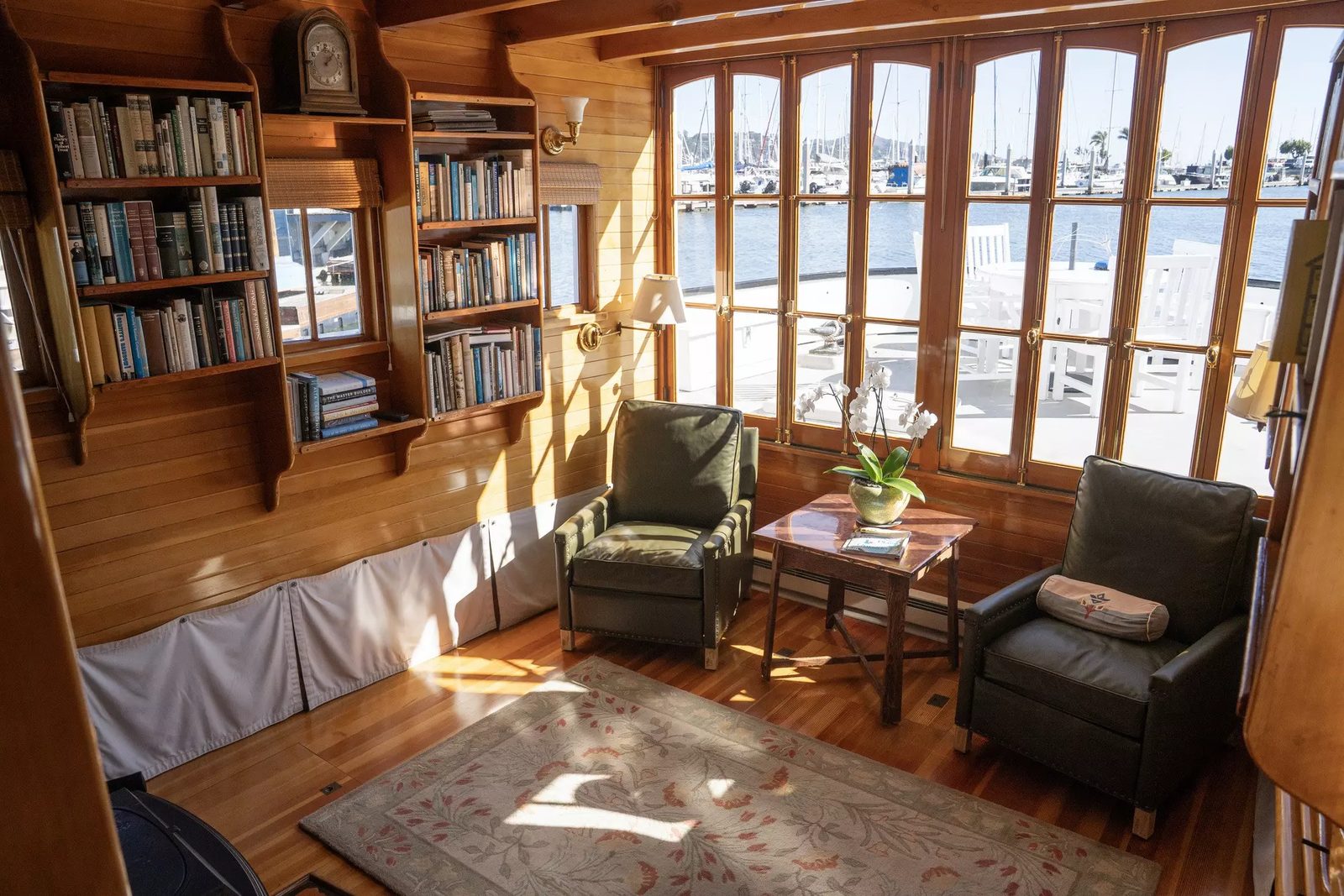 The redwood-panelled living room of Stewart Brand's Sausalito houseboat, bookshelves and windows onto the marina