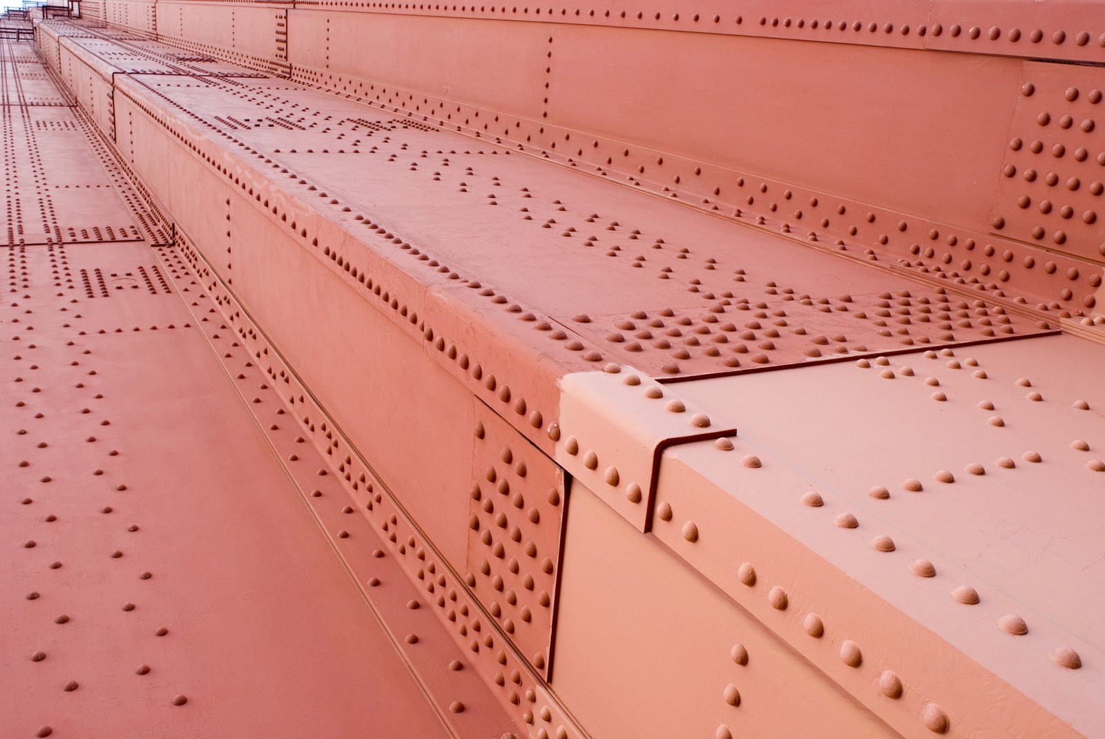 Rows of rivets across the orange steel plating of the Golden Gate Bridge